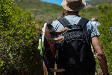 person with a backpack and surfboard adventuring 