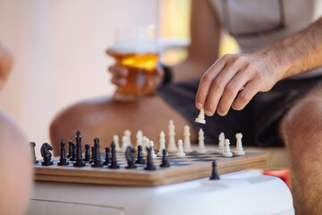 person playing chess with a beer