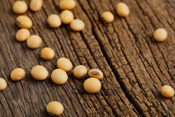 Dry soybean seed on wooden background.