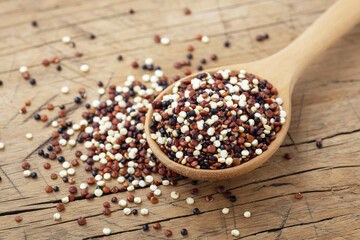 Quinoa in spoon, closeup on wooden table