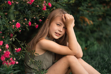 very beautiful little girl near the roses