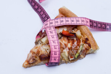 Pizza slice with measuring tape on white background. diet concept, healthy food concept