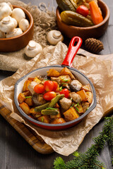 Fried potato with mushrooms served in frying pan