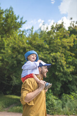 Father holding his son in his arms. Parental love. A father walks with his son for fun. Time for father and son. Happy fatherhood.