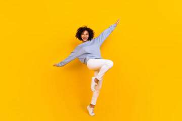 Fototapeta na wymiar Full length photo of satisfied charming girl raise hands enjoy free time isolated on yellow color background