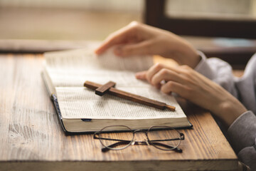 Close-up of hands on the Bible. The process of studying the Bible. Prayer and worship of God. Study of the Holy Scriptures. Studying in theological seminary. Theology.