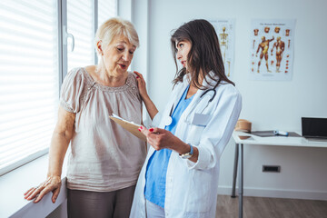 Charming female doctor giving advice to a senior female patient. Mature woman visiting doctor in...
