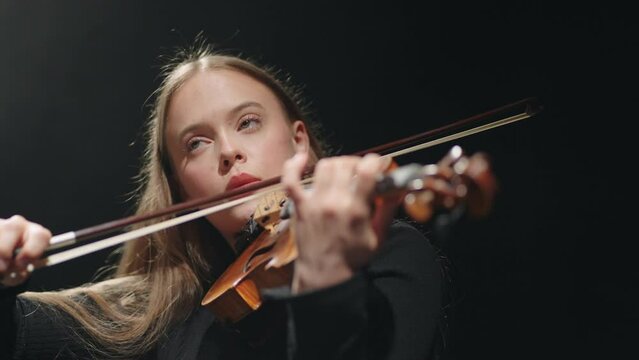 inspired female fiddler is playing classic music concert in philharmonic hall, violinist is playing fiddle