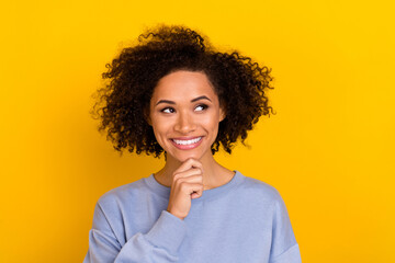 Photo of sweet pretty wavy lady wear blue sweatshirt arm chin looking empty space isolated yellow color background
