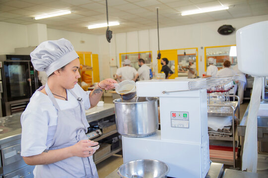 Woman pouring ingredient into mixer
