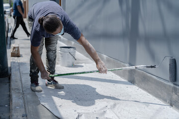 Woman painting wall on street