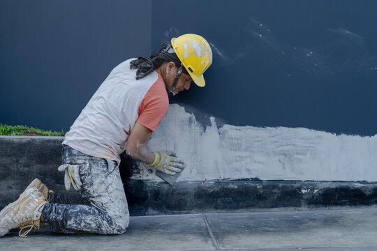 Man plastering wall on street