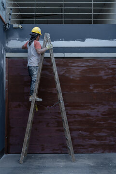 Man plastering wall on street
