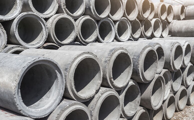 Concrete drainage pipes for industrial building construction. Pipes stacked together in layers to...