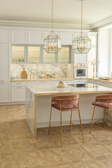 a close view of the white stylish kitchen with a cooking island in the luxurious interior of a modern apartment in light colors with stylish furniture.