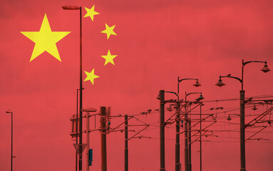 China flag with tram connecting on electric line with blue sky as background, electric railway train and power supply lines, cables connections and metal pole overhead catenary wire