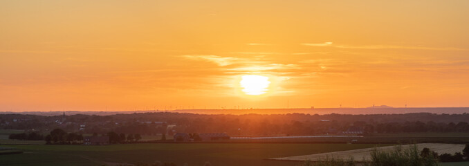 Obraz premium A golden sunset over the rolling hills in Banholt, south Limburg in the Netherlands creating holiday vibes. The views and the warm glow over the landscape create a feeling of being in the Mediterranea