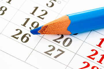 Monthly calendar and a blue pencil to mark the desired date