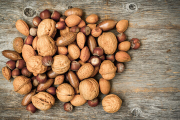Pile of assorted nuts on wooden background