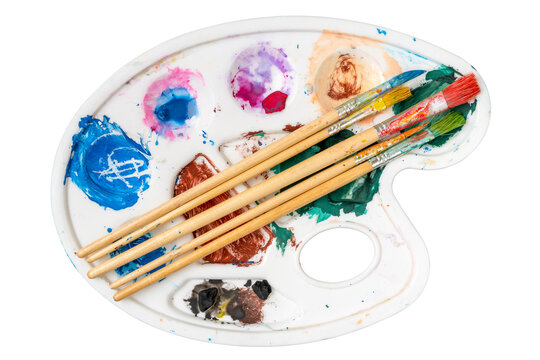 Paintbrush set on the art palette with stains of watercolor paint