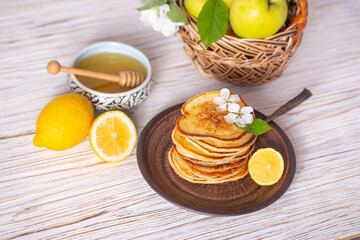 Fototapeta na wymiar Pancakes with honey, lemon and apple