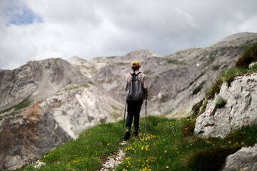 Rear View of Backpacker Female Trekker Hiking on Top of Julian Alps in Slovenia