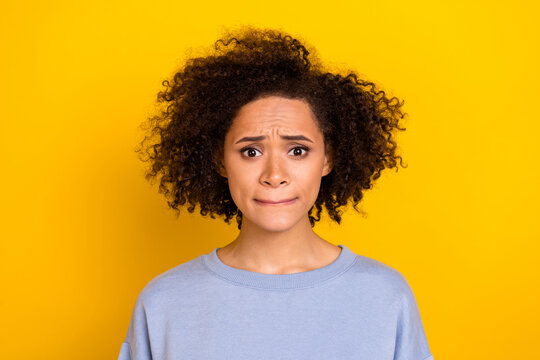 Photo of stressed depressed wavy lady wear blue sweatshirt biting lips hearing bad news isolated yellow color background