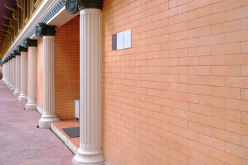 Perspective view of red brick wall with an empty sign in front of the entrance - Powered by Adobe