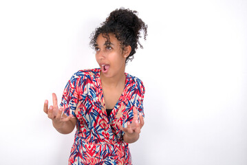 Young African American woman wearing colourful dress over white wall crying and screaming. Human emotions, facial expression concept. Screaming, hate, rage.