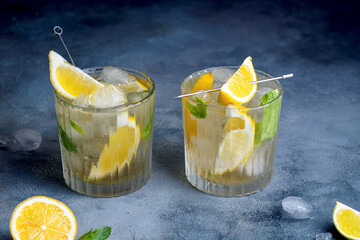 citrus lemonade with mint and lemon in the glass with ice cubes.