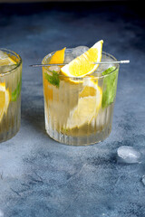 citrus lemonade with mint and lemon in the glass with ice cubes.