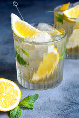 citrus lemonade with mint and lemon in the glass with ice cubes.