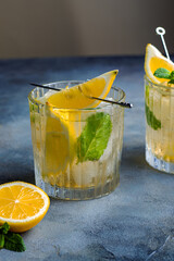 citrus lemonade with mint and lemon in the glass with ice cubes.