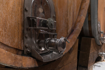 Stacked wooden barrels in a wine cellar, production and aging red wine in the traditional way