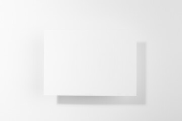 White blank card for text mockup in hard light with shadows soar on soft light white background. Simple modern template for advertising, branding identity, greeting card, poster, design, flyer.