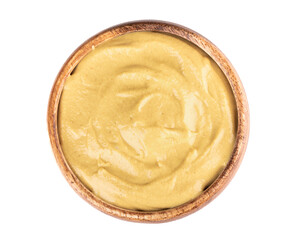Wooden bowl full of Dijon mustard isolated on white background.