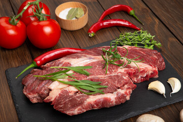 Raw beef steak on wooden table top. Healthy food concept. beef cut and spices for cooking bbq sauce