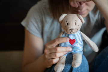 Perinatal loss reproductive chalenge concept - female holding a teddy bear toy