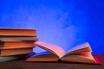 Open book on the table. Education and reading concept. Retro neon light