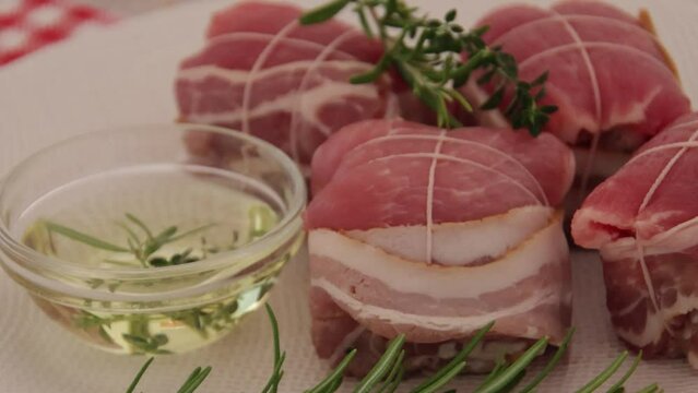 paupiettes de porc cru &agrave; l'huile et aux romarin dans une assiette 