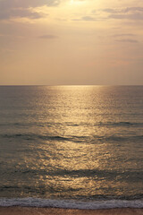 Sunset on the beach. Scenic seascape with clouds, waves and sun.