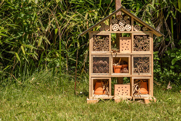 Insect house in the garden. Bug hotel at the park with plants in Switzerland.