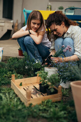 mother and daughter enjoying gardening in home backyard