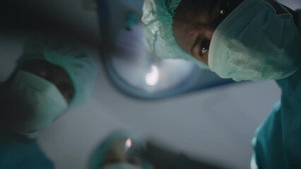 Point of view of patient with African American teams surgeons processing surgical operation looking into the eye for treatment in operating room hospital emergency department, POV eye blinking effect.