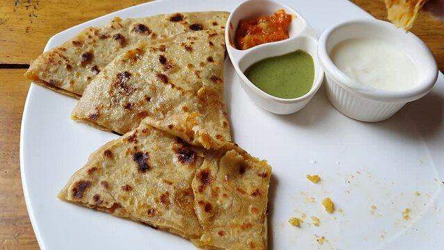 eating soft aloo paratha / potato stuffed flat bread