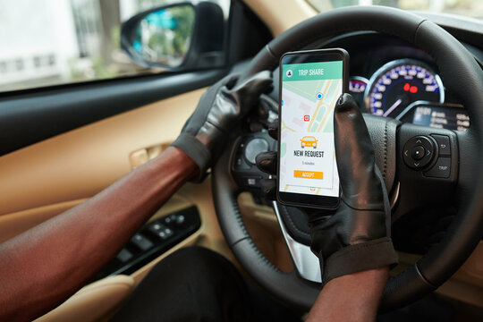 Close-up image of car owner checking request in car sharing application on smartphone
