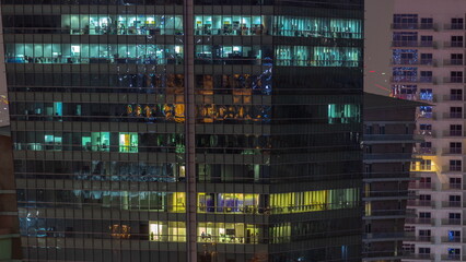 Fototapeta na wymiar Windows illuminated at night in modern office buildings timelapse.