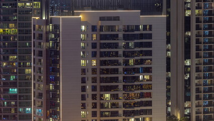 Fototapeta na wymiar Windows illuminated at night in modern residential buildings timelapse.