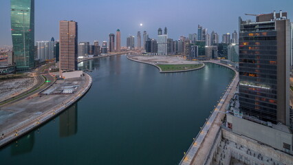 Obraz premium Cityscape of skyscrapers in Dubai Business Bay with water canal aerial night to day timelapse