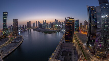 Cityscape panorama of skyscrapers in Dubai Business Bay with water canal aerial day to night timelapse